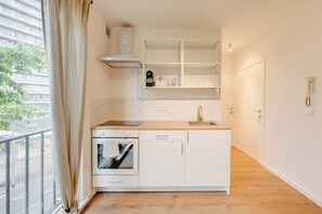 Een compacte keuken met een ingebouwde oven, een spoelbak en een fornuis.