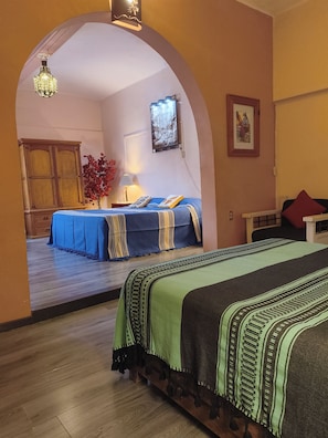 A room with a bed, a desk, a chair, a lamp, a picture frame, and a window with a view. - Oaxaca Loft (Oaxaca de Juárez)