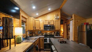 Una cocina moderna con armarios de madera, electrodomésticos de acero inoxidable y una zona de comedor con banco.