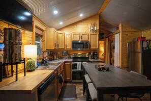 Eine moderne Küche mit Holzschränken, Edelstahlgeräten und einer Essecke mit einer Bank.