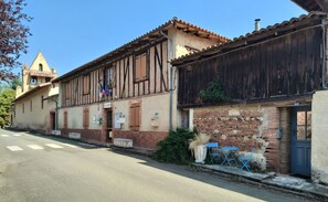 A traditional building with a sign reading 'MAIRIE' and a small outdoor seating area with blue chairs.