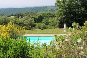 Ein Schwimmbad mit Blick auf eine bewaldete Landschaft.