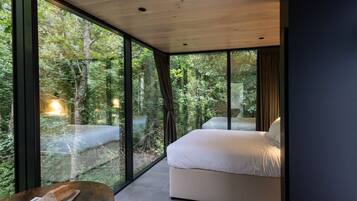 Quarto com uma janela grande, uma cama e uma mesa com comida.