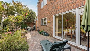 A brick house with a patio, outdoor furniture, and a garden. - Host & Stay | Worthing Getaway (Worthing)