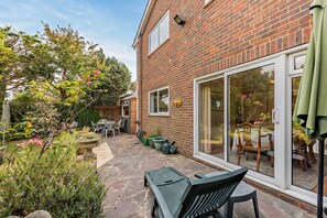 A brick house with a patio, outdoor furniture, and a garden. - Host & Stay | Worthing Getaway (Worthing)