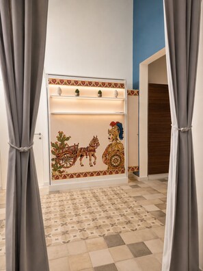 Una habitación con piso estampado, una pared con detalles decorativos y cortinas.