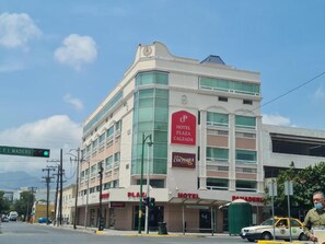 Un hotel con un llamativo letrero que dice 'Hotel Plaza Calzada', un restaurante 'La Cucumara' y una entrada 'Plaza'.
