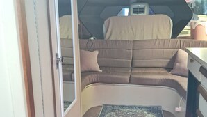 A compact living space with a sofa, a rug, and a table. - The Pink Lady Yacht - Beautiful Providence Marina (Providence)