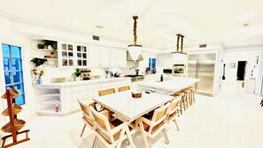 A spacious kitchen with white cabinetry, a large island, and modern appliances. - Luxury 7BR Pacific Palisades Wellness Estate with Pool (Los Angeles)