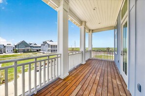 A covered porch with a view of houses and a clear sky. - Vacay all Day 115 DEW (Port Aransas)