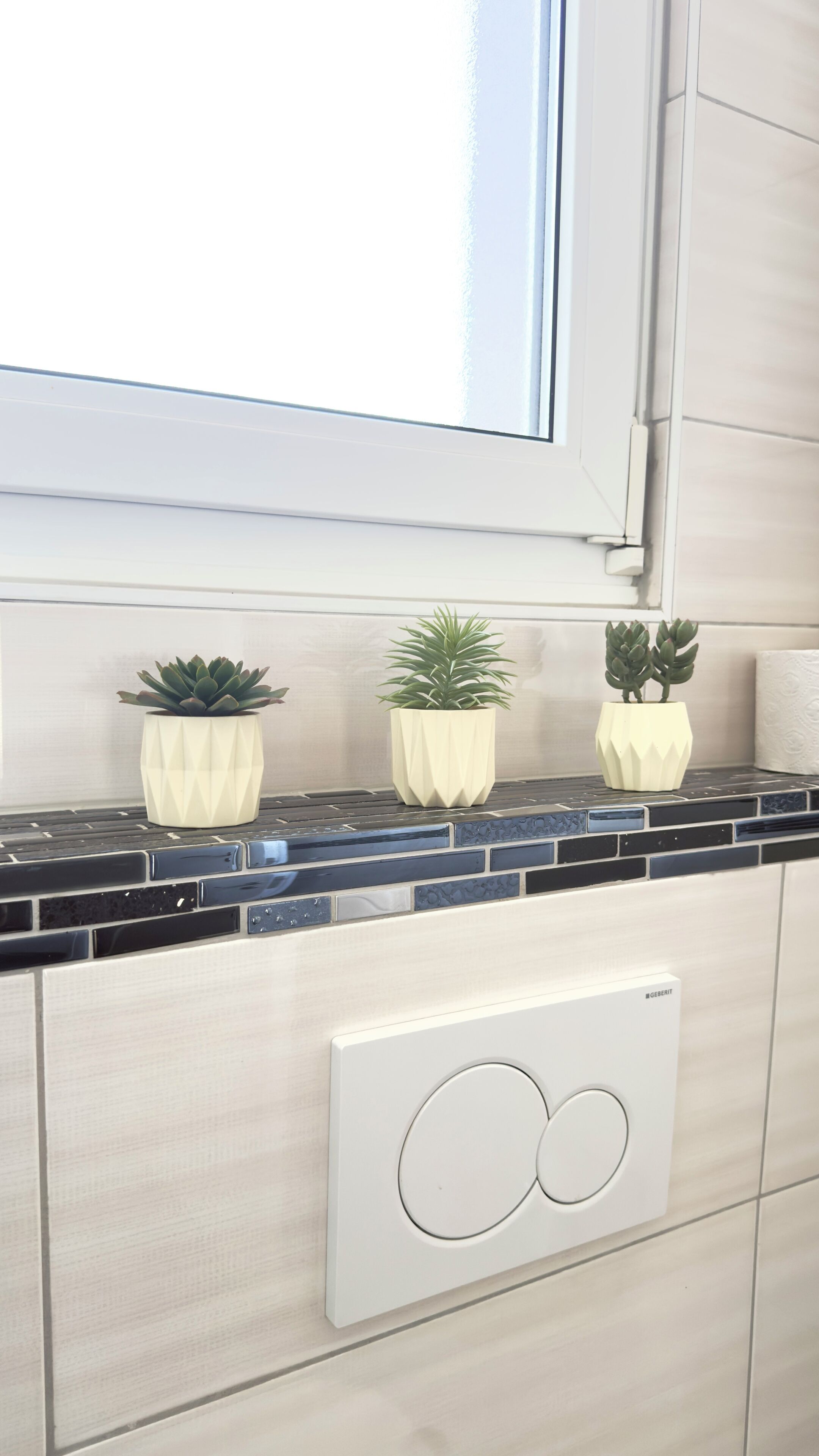 Eine Küche mit schwarzem Arbeitsplatz, drei weißen Blumentöpfen und einem GEERMIT-Backofen.