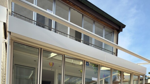 A modern building with large glass windows and a flat roof.