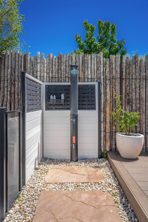 A gated outdoor area with a metal gate, a potted plant, and a pathway made of pebbles. - Resort-Style City Oasis with Heated Private Pool & Hot Tub (Santa Fe)