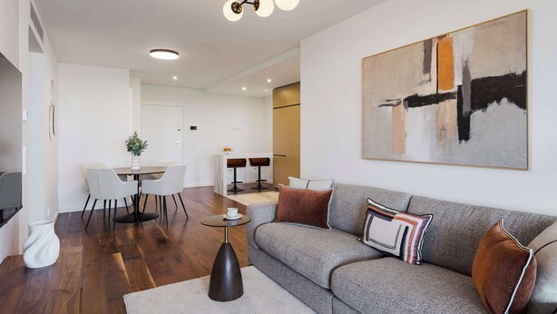 A modern living room with a sectional sofa, a coffee table, and a dining area with chairs and a table. - Private Heated Pool & Dom Luis Views by HostWise (Vila Nova de Gaia)