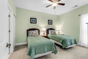 A bedroom with two beds, a ceiling fan, and two bedside lamps. - World Tour Fairway Condo • Pool • 10 Min to Beach (Myrtle Beach)