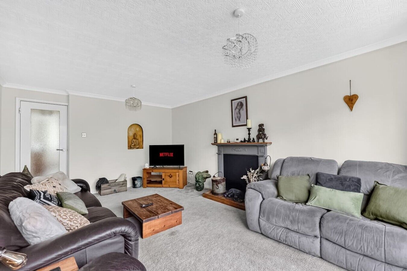 Una sala de estar con chimenea, televisión y sofá.
