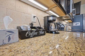 Eine Küche mit einer Kaffeebar, einer Kaffeemaschine und einem Schild, das darauf hinweist, die Küche vor der Abreise der Gäste zu reinigen.