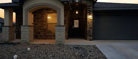 A residential building with a stone facade, a garage, and a driveway.
