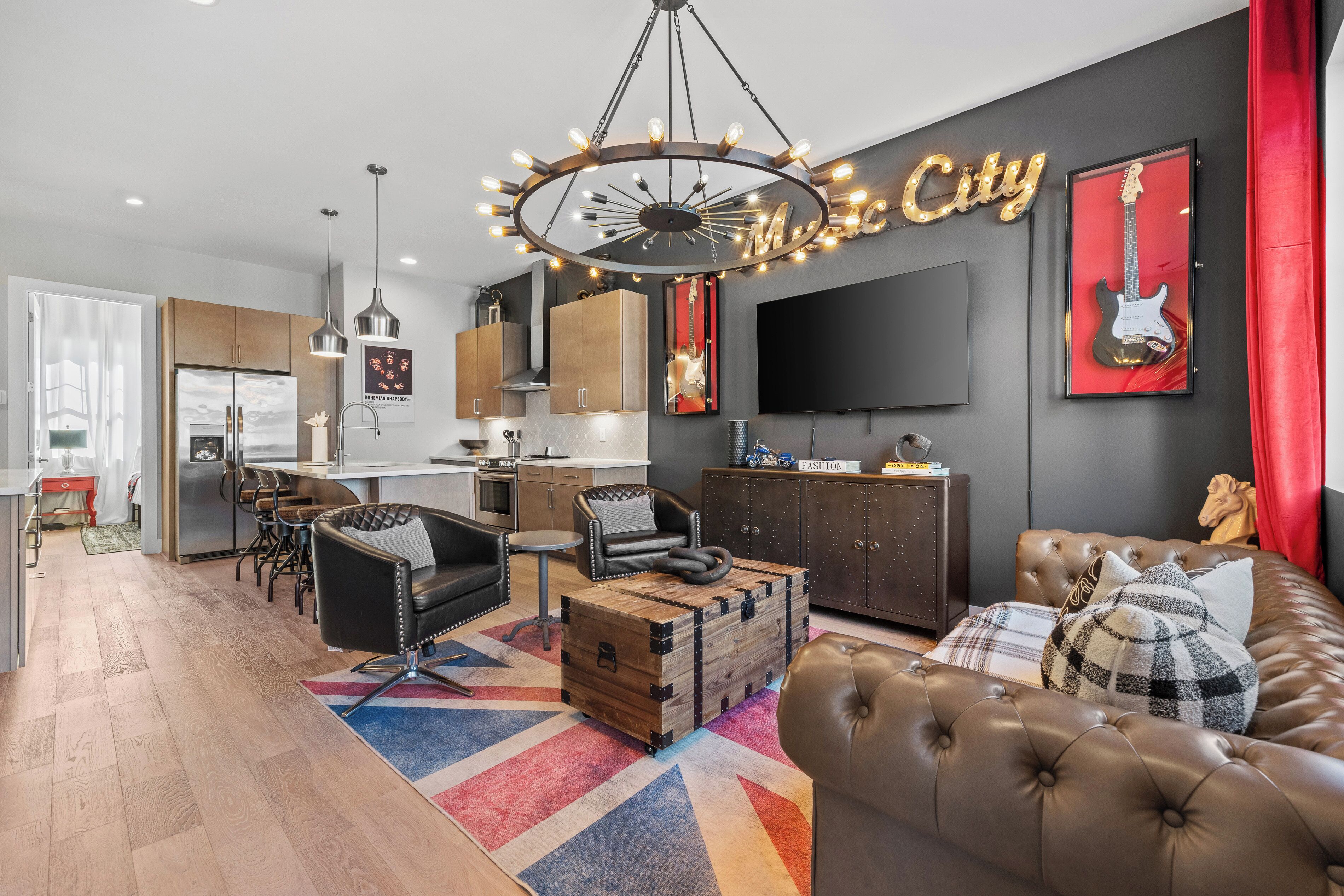 A modern living room with a large sofa, a coffee table, and a dining area with a kitchen in the background.