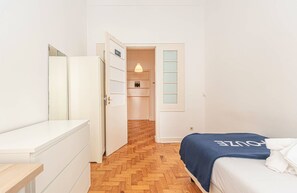 Ein Hotelzimmer mit einem Bett, einem Schrank, einem Spiegel und einer Tür zu einem Badezimmer.