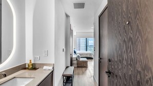 A modern bathroom with a large mirror, a sink, and a bottle of hand soap. - Pied A Terre With Roof Pool (Miami)