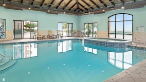 An indoor swimming pool with clear water, surrounded by lounge chairs and a hot tub. - Seaside Sanctuary - Beachfront (Orange Beach)