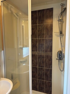 Een douche, handdoeken, zeep, toiletpapier
