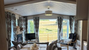 Ein modernes Interieur mit Essbereich, Sitzgelegenheiten und Fernseher.