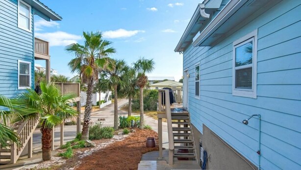 A residential area with two-story houses, a narrow driveway, and palm trees. - Sun and Sand (Panama City Beach)