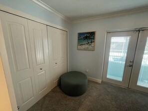 Ein Zimmer mit Schrank, Gemälde, Tür und Teppichboden.