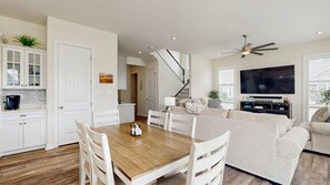 A modern living space with a dining area, kitchen, and a large TV. - Ocean View Beach Club - 18 Middlesex Dr (Ocean View)