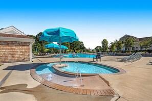 A swimming pool with a water feature, surrounded by lounge chairs and umbrellas. - Ocean View Beach Club - 18 Middlesex Dr (Ocean View)