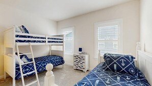Ein Schlafzimmer mit Etagenbetten, einem Schminktisch und einem Nachttisch.