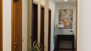 Ein Flur mit Holztüren, einem Blumentopf und einem Gemälde an der Wand.