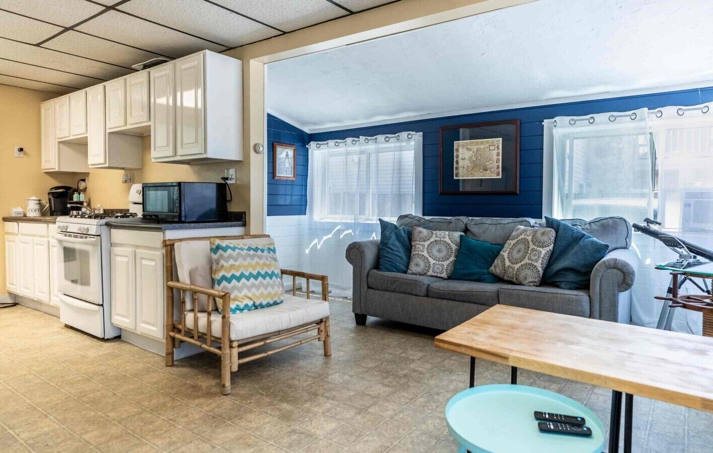 A compact living space with a kitchenette, a sofa set, and a dining area.