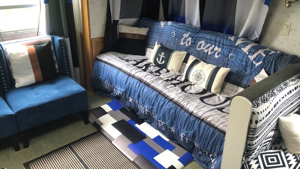 Ein gemütlicher Wohnbereich mit Sofa, Sessel und einem gemusterten Teppich.