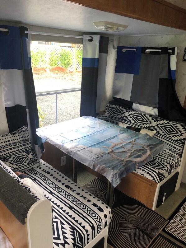 A compact room with a bed, a table, and a bench.