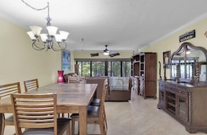 A dining area with a wooden table and chairs, a chandelier, and a ceiling fan. - Exec Bay Resort-Style 4BR Townhome w/Beach, Marina, Heat/Chill Pool & Pickleball (Islamorada)