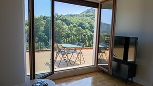 A room with a large sliding glass door leading to an outdoor patio with a table and chairs. - The Rooftop Apartment A (Basauri)