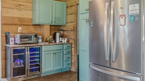 A compact kitchen with a stainless steel refrigerator, a microwave, and a built-in oven.