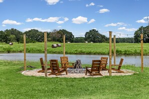 Un espacio de descanso junto al lago con sillas de madera y un hogar.
