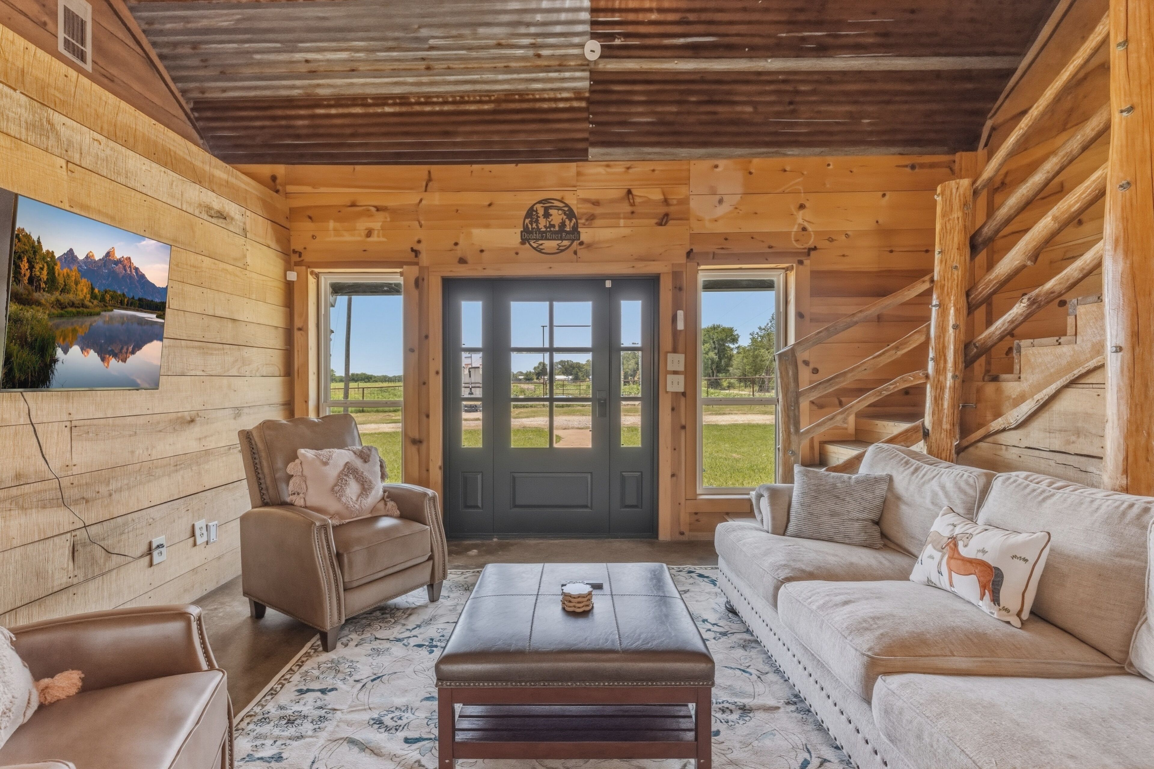 A wooden cabin interior with a sofa, armchair, and a coffee table.