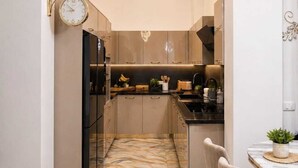 A modern kitchen with a marble floor, a dining area with a table and chairs, and a pendant light. - Gold Apartment NAAMABAY near the beach with a free shuttle (Sharm el-Sheikh)