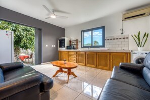 A modern kitchen with a dining area, a ceiling fan, and a view of the outdoors. - Vétyvers - Climatisation - Terrasse (Saint-Louis)