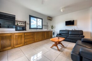 A modern kitchen with a built-in oven, microwave, and a large window. - Vétyvers - Climatisation - Terrasse (Saint-Louis)