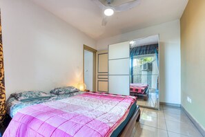 A bedroom with a bed, a wardrobe, a mirror, and a window. - Vétyvers - Climatisation - Terrasse (Saint-Louis)
