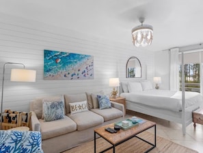 Ein modernes Hotelzimmer mit Bett, Sofa und einem Bild an der Wand.
