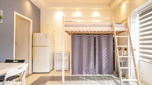 A compact room with a bunk bed, a small table, a refrigerator, and a curtain. - Le Local - Climatisation - Petfriendly (Saint-Martin-d'Hères)