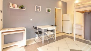 A compact living space with a kitchenette, a dining area, and a small seating area. - Le Local - Climatisation - Petfriendly (Saint-Martin-d'Hères)