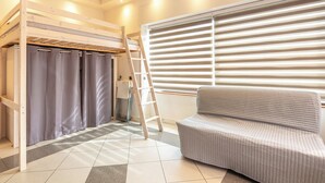 A room with a bunk bed, a sofa, a ladder, and a window with blinds. - Le Local - Climatisation - Petfriendly (Saint-Martin-d'Hères)